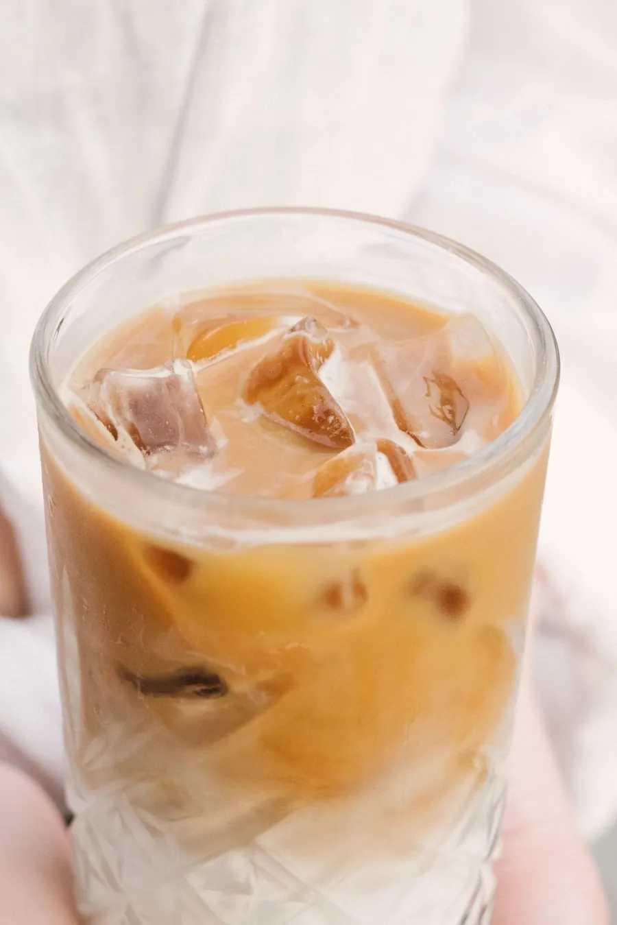 Brown Sugar Oat Latte, creamy and iced, in a textured glass